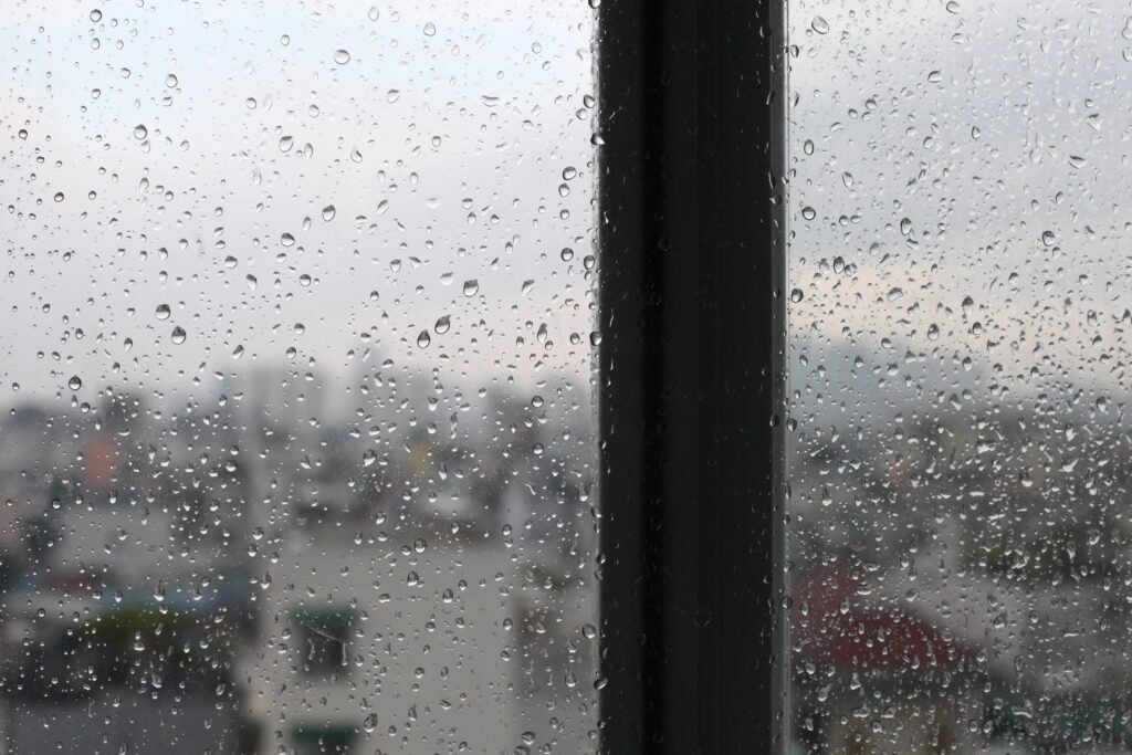 Vintage looking Urban scene seen through a window in a rainy day.