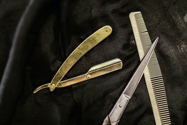 A straight razor, scissors and a comb